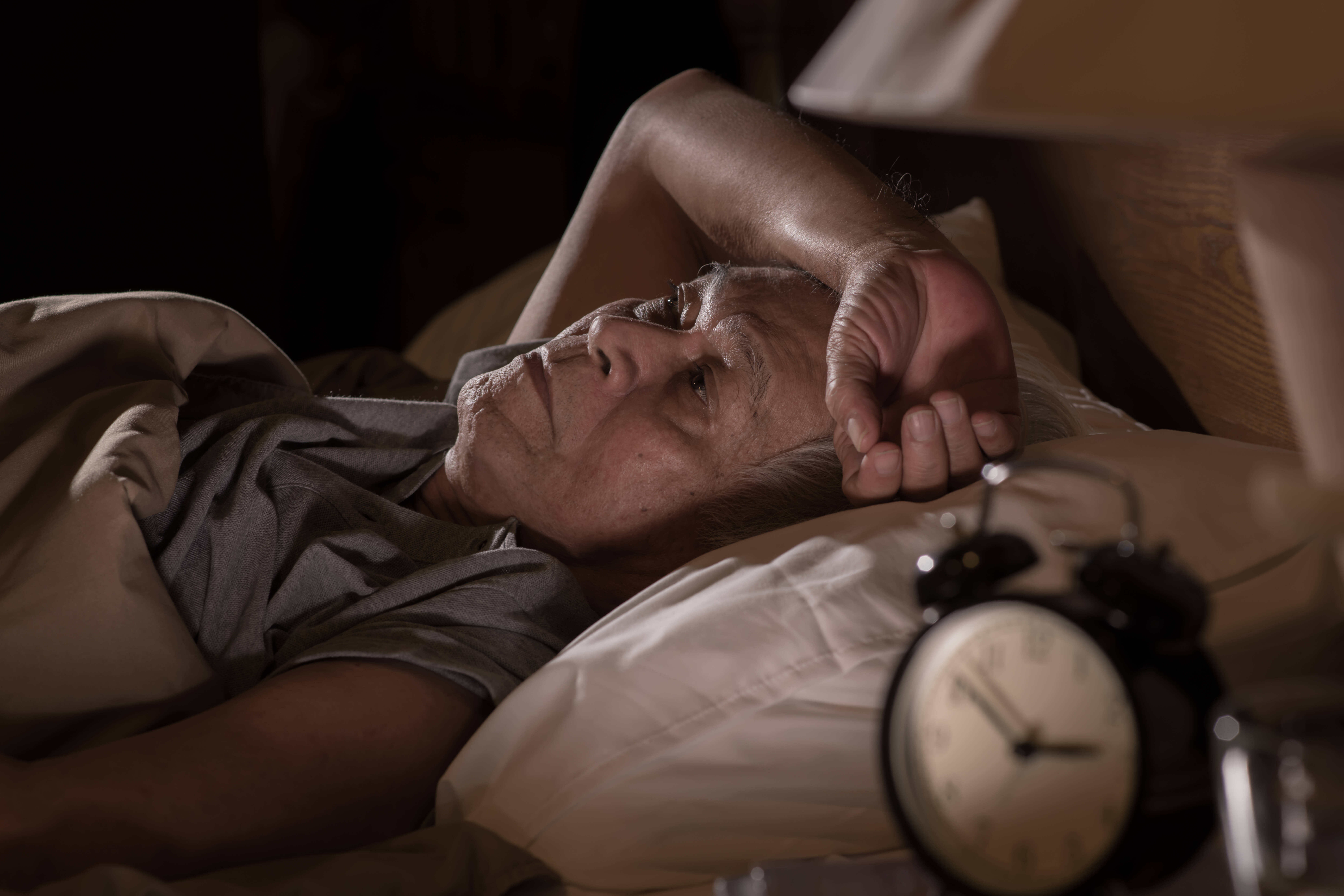 Older man awake, can't sleep, insomnia