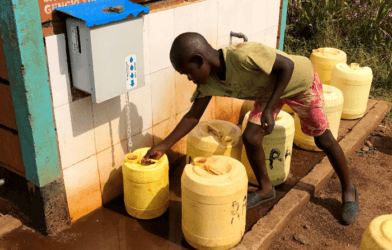 Child retrieves chlorine treated water from a rural kiosk in Kenya